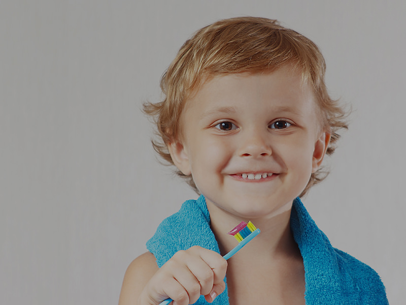 niño sonriente con cepillo dental